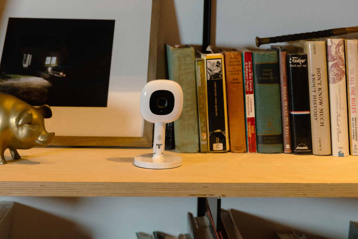 nanit baby monitor on flex stand sitting on living room bookshelf