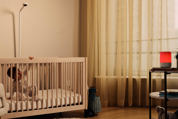 baby in crib with nanit baby monitor and sound + light