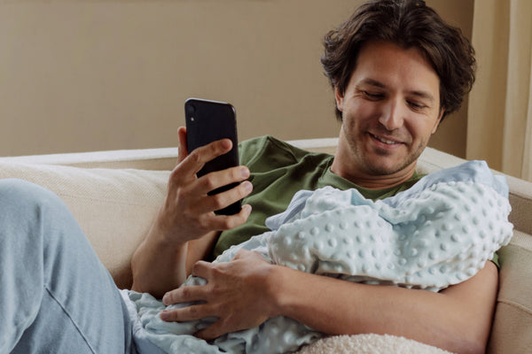 Dad holding new baby with cell phone