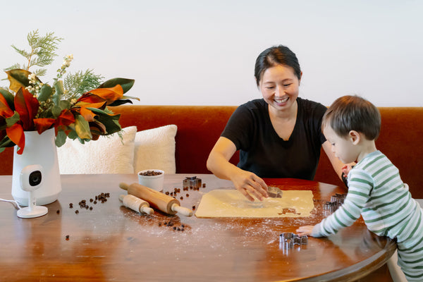 mother and child making cookies with nanit baby monitor