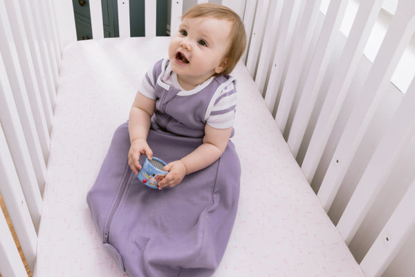 baby in crib wearing sleep sack