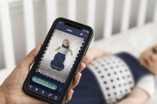 Nanit App with breathing Motion Monitoring feature and baby in Breathing Wear in the background