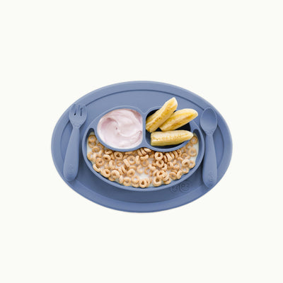 ezpz mini feeding set in indigo filled with cereal, yogurt, and fruits 