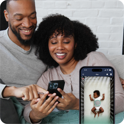 couple looking at mobile nanit app while child is sleeping