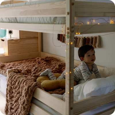 Toddler in bed with Nanit Pro Baby Monitor and Flex Stand in background