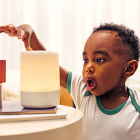 Toddler looking at nanit sound + light with surprised look