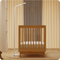 baby crib in room with nanit pro baby monitor floor stand on side of crib