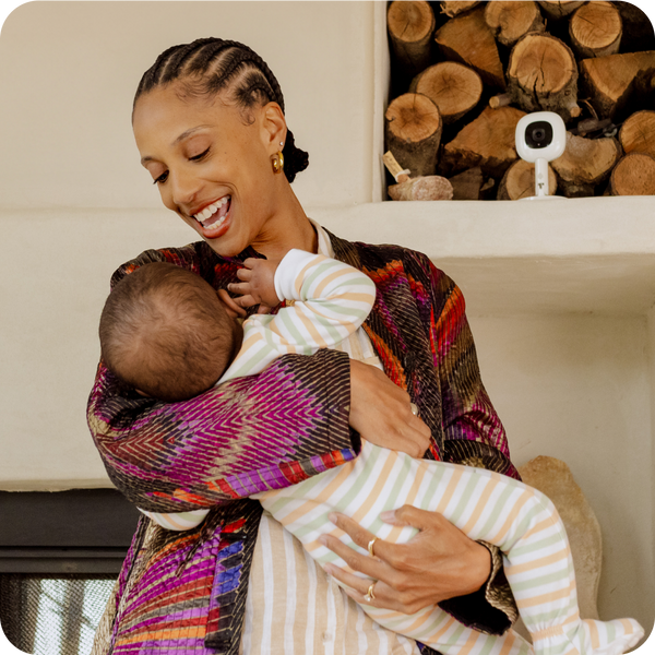 mom holding baby and smiling while pro camera + flex stand placed on top