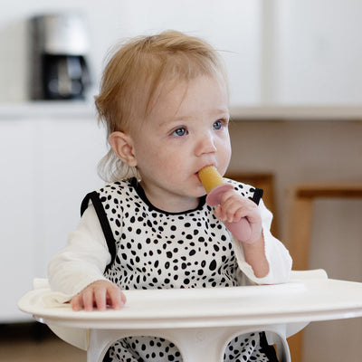 baby holding and sucking on tiny pops 