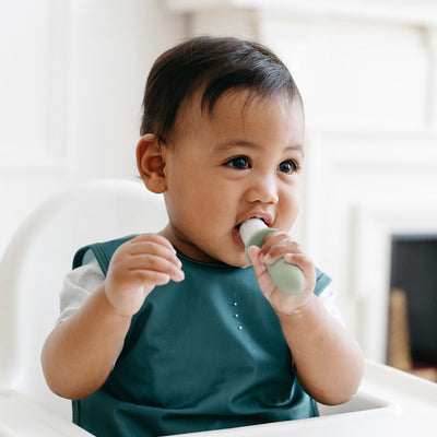 baby holding and biting on tiny pop 